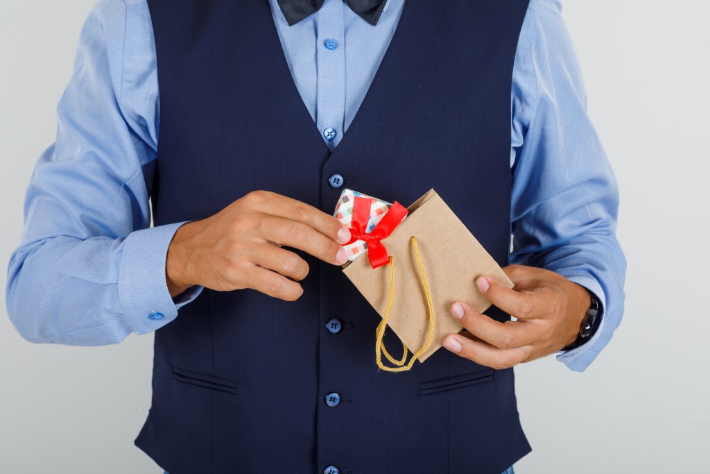young-man-taking-present-out-of-paper-bag-in-suit.jpg young-man-taking-present-out-of-paper-bag-in-suit.jpg